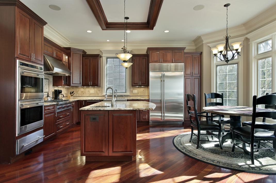 Contemporary brown kitchen with cherry cabinets and brown floor