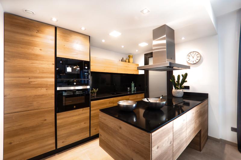 Bold Kitchen Island with silver range hood