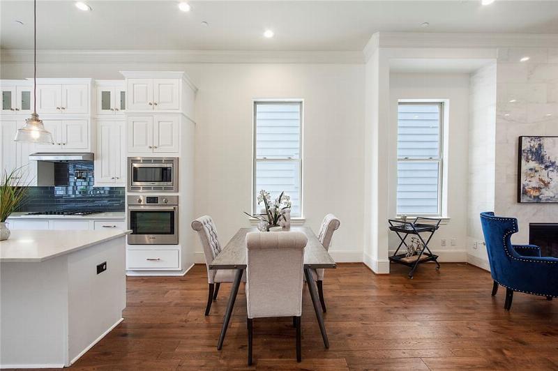 Photo 3: Modern kitchen featuring a center island, hardwood floor and quartz counter.